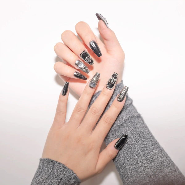 Angolazione artistica mani con unghie gotiche nere, decorazioni argento eleganti