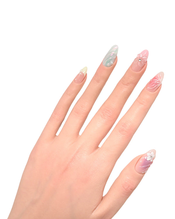 Mano con dita allungate mostrando press on nails Dolci Sussurri Floreali, eleganza soft e femminilità naturale con sfumature pastello e decorazioni floreali delicate