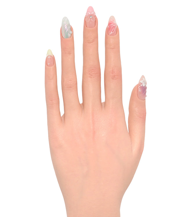 Mano palmo aperto con press on nails Dolci Sussurri Floreali mostrando sfumature pastello rosa azzurro verde, decorazioni floreali, perle e cristalli romantiche