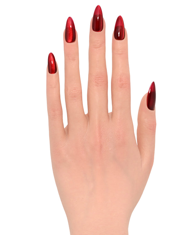 Mano con press on nails Rosso Seducente palmo aperto per Natale 2025, mostrando effetto cat eyes metallizzato con riflessi spettacolari perfetti per feste natalizie